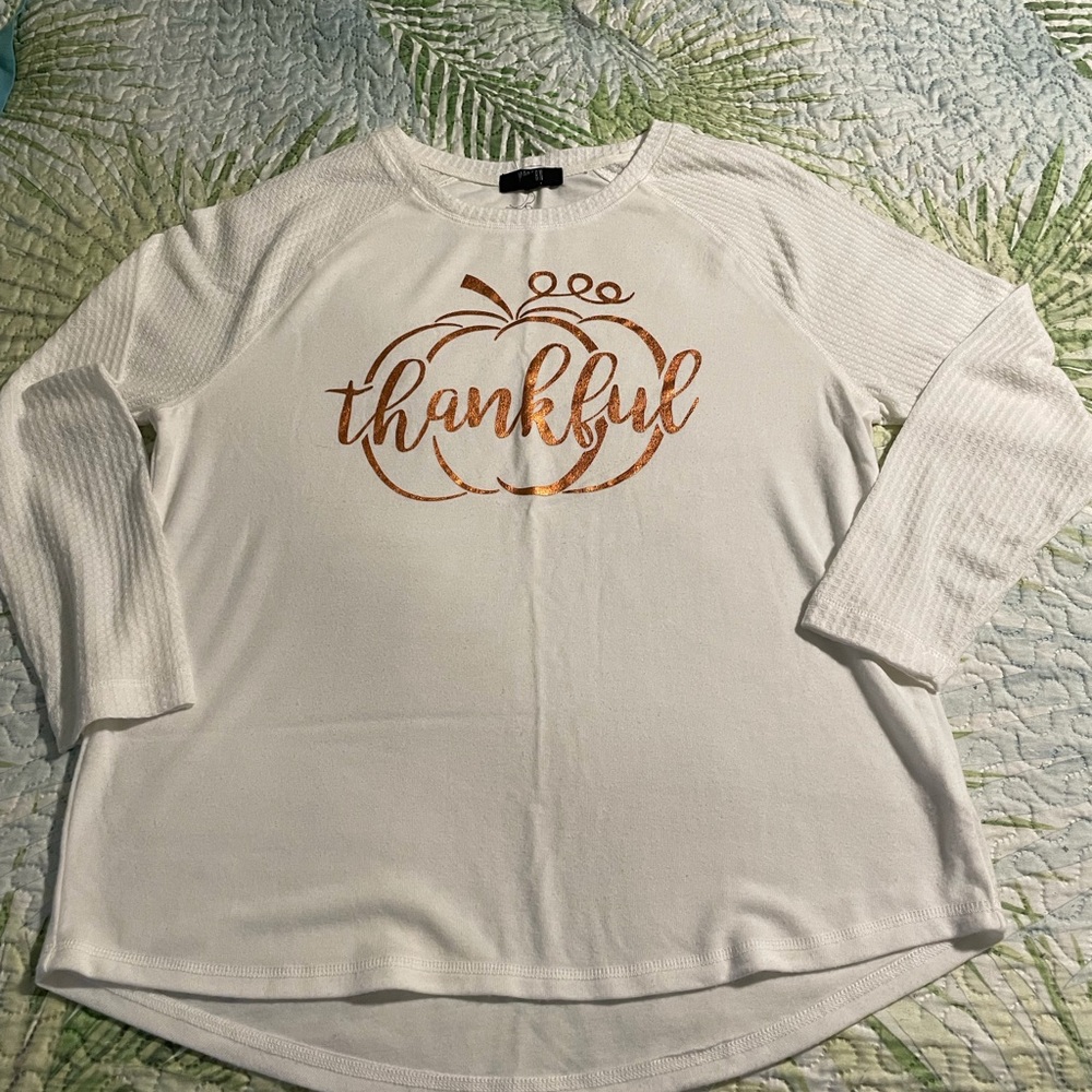 Long sleeve cream shirt with “Thankful” on it.